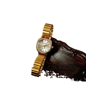 Vintage gold women's watch with fluted bezel and quartz movement on metal link strap