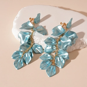 Close-up of blue acrylic petal tassel earrings with gold spiral clip-on mechanism