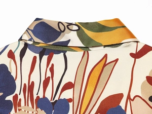 Detailed macro view of shirt neckline featuring colorful abstract print and satin silk fabric