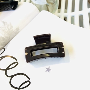 Macro detail of rectangle hollow hair claw clip with dark polished finish and strong spring