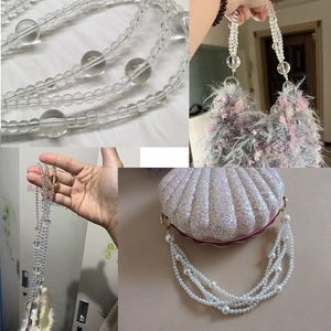 Detail of transparent acrylic bead chain handle attached to a faux fur handbag
