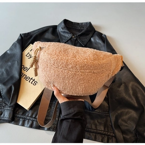Detail of apricot fleece sling bag showing plush texture and woven zipper puller accents