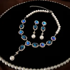 Vintage necklace and earring set with blue oval gems, diamonds and pearls in velvet tray