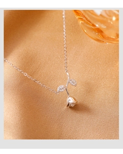 Detail of S925 sterling silver rose pendant with shimmering diamond-set leaves on velvet