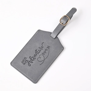 Gray faux leather luggage tag featuring engraved adventure quote and secure strap