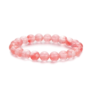 Close-up of pink natural stone beaded bracelet with smooth round quartz beads on white background