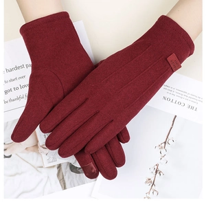 Gros plan de gants thermiques bordeaux avec fonction tactile et détails de coutures à trois