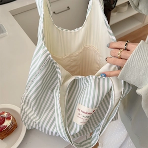 Detail of green striped canvas tote bag showing inner pocket and spacious interior
