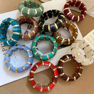 Colorful acrylic resin bangles with gold metal spacers in a vintage stackable style