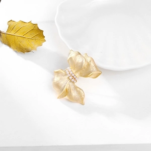 Elegant gold bow brooch with brushed metal finish and white pearls for stylish women