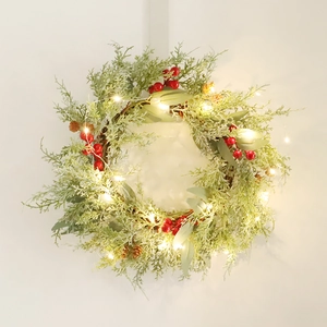 Christmas wreath with PE red berries pine cones and warm LED lights on white background