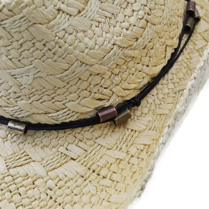 Close-up of handmade paper straw hat featuring vintage bronze metal tubes and black cord