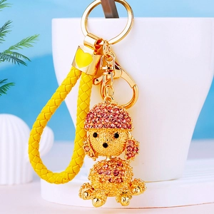 Detailed close-up of a rhinestone puppy keychain with a yellow braided rope and gold ring