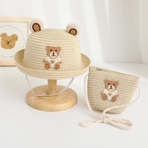 Detail of straw hat and bag set for kids with cute teddy bear ears and woven pattern