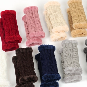 Détail de mitaines en tricot colorées avec bordure en fausse fourrure douce en plusieurs tons