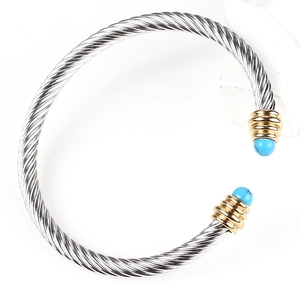 Silver cable cuff bracelet with gold screw-end detail and blue gemstone accents