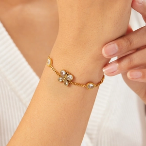 Elegant gold plated stainless steel bracelet with butterfly and zircon flower on a wrist
