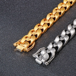 Close-up of hip-hop Cuban chain bracelet with engraved skull details in gold and silver