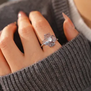 Bague trèfle élégante en argent avec zircons portée au doigt d'un mannequin