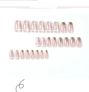 Close-up of pink press-on nails with gold french tips, plaid patterns, and glitter details