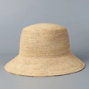 Dettaglio ravvicinato della trama in rafia di qualità su un cappello beige da sole