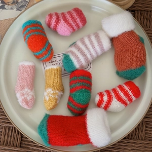 Miniature colorful knitted Christmas socks in assorted patterns on a decorative plate