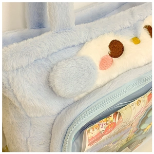 Detail of the light blue plush shoulder bag featuring a transparent PVC display window
