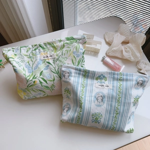 Floral print and striped cotton makeup bags with simple wish label on white desk