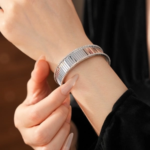 Détail du bracelet jonc argenté à rayures avec zircons sur fond de velours élégant
