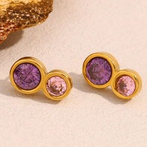 Detailed shot of double circle gold stud earrings with purple and pink cubic zirconia