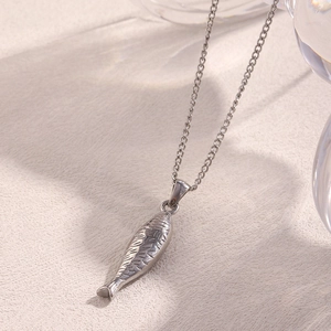 Vue macro d'un collier avec pendentif poisson saumon argenté sur chaîne O élégante
