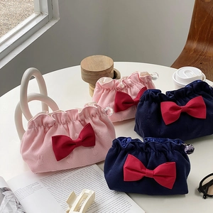 Flat lay of pleated cosmetic bags with red satin bows and crystal zipper pendants