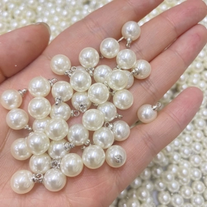 Primo piano di ciondoli con perle bianche e anelli in metallo argento per gioielli fai da te