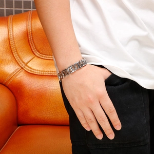 Close-up of a silver Cuban link bracelet with cross motifs on a male wrist