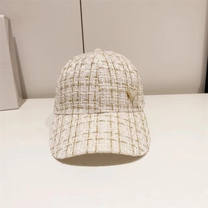 Close-up of the textured tweed fabric and metallic heart detail on the baseball cap