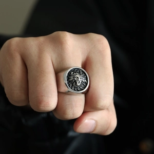 Close-up of vintage lion head signet ring in cast titanium steel on man's finger