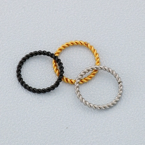 Three minimalist braided twisted rope rings in black, gold, and silver stainless steel