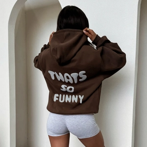 Close-up of white 3D puff print lettering on the back of a dark brown oversized hoodie