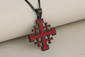 Macro shot of black and red Jerusalem cross pendant on a matching metal chain