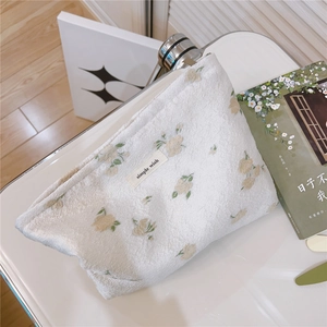 Detail of floral makeup bag featuring a soft towel fabric texture and simple wish logo