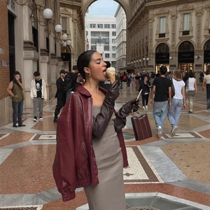 Vintage burgundy woven faux leather bomber jacket styled with midi skirt in classic city street