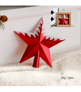 Red glitter Christmas tree topper star with white decorative details in macro view