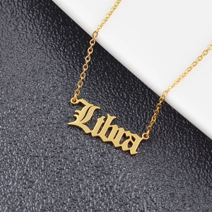 Macro view of gold Libra zodiac pendant in Gothic font on stainless steel necklace