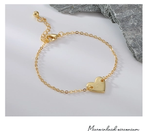 Détail du bracelet cœur doré avec gravure de la lettre D et oxydes de zirconium sertis
