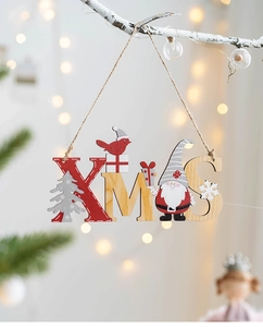 Detail of wooden XMAS letter sign with reindeer and gnome motifs on a frosted branch