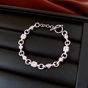Detail of silver chain bracelet with zircon stones and toggle clasp on leather