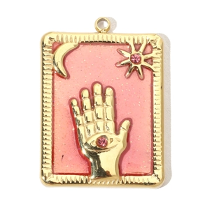Detail of a gold rectangular pendant featuring embossed sun, moon, and eye with pink gemstones