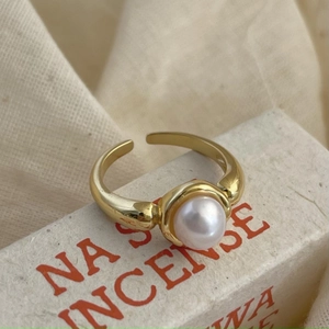 925 silver adjustable gold ring with a large white pearl on a vintage paper box
