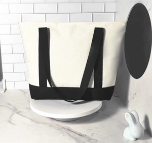 Detailed view of bicolor canvas tote bag on display with black handles and bottom