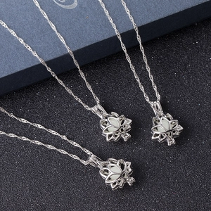 Three glowing lotus flower locket necklaces in silver finish on a textured black background